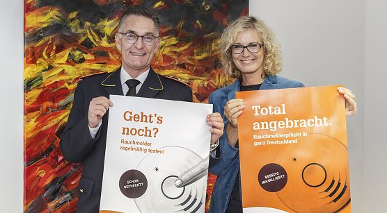 Hartmut Ziebs, Pr&auml;sident des Deutschen Feuerwehrverbandes (DFV), und Claudia Groetschel, Sprecherin der Initiative Rauchmelder retten Leben stellten gemeinsam die Plakate zum Rauchmeldertag 2017 vor. (Foto: privat)