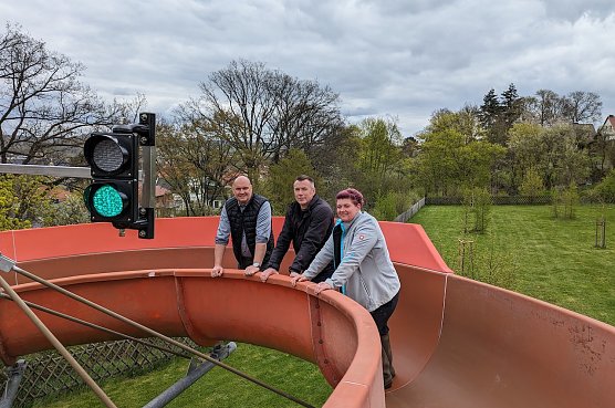 Bildunterschrift: B&uuml;rgermeister Steffen Grimm (links), Elektroinstallateur Heiner Chinow (Mitt) und Bergbadchefin Mandy G&ouml;ssel (rechts) pr&uuml;ften die neue Ampel f&uuml;r die Rutsche auf Funktionstauglichkeit (Foto: Janine Skara)