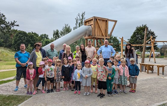 B&uuml;rgermeister Steffen Grimm (hinten 2.v.re), die Kinder und Erzieherinnen der Kita Pusteblume, Christian Duft und Babett Knobloch, Mitarbeiter aus dem Sachgebiet Gr&uuml;nplanung der Stadtverwaltung Sondershausen, sowie Vertreter der ausf&uuml;hrenden Bau- und Planungsfirmen er&ouml;ffneten den Bergbau-Spielplatz im Hasenholz/&Ouml;stertal. (Foto: Janine Skara)