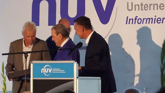 NUV-Ehrenpr&auml;sident Hans-Joachim Junker &uuml;berreichte Schr&ouml;der eine Flasche Doppelkorn einer limitierten Edition. (Foto: nnz)