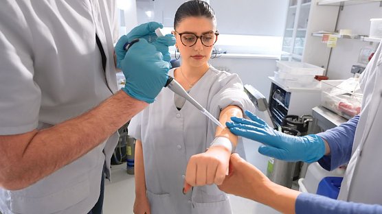 Schutz&shy;film: Das Pr&uuml;f&shy;team tr&auml;gt eines der Produkte auf den gereinigten Unter&shy;arm der Probandin auf - exakt dosiert und systematisch. (Foto: Stiftung Warentest)