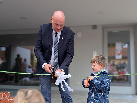 Der gro&szlig;e und der kleine B&uuml;rgermeister durchschnitten das Schleifenband und gaben die Kita offiziell frei (Foto: Janine Skara)