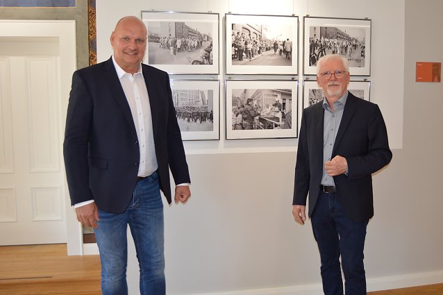 Bild:  B&uuml;rgermeister Steffen Grimm und Henryk Bies vor den Fotos der Ausstellung im Rathaus.