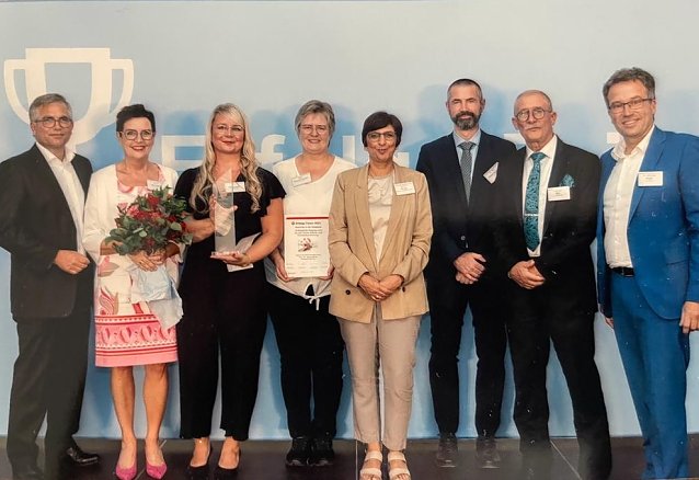 Bild: Preisverleihung Erfolge feiern - Karsten Frob&ouml;se, Andrea Springer, Katrin Windolph, Meike Bauermeister, Dr. Tim Malolepszy und Andreas Bol (v.l.n.r.) nehmen stellvertretend f&uuml;r alle an TiP Beteiligten die Auszeichnung des Vorstands der BA, vertreten durch Vanessa Ahuja (Mitte), und des Vorsitzenden des Vorstandes Arbeitsmarktservice &Ouml;sterreich Dr. Johannes Kopf (rechts) entgegen 