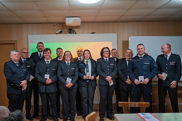 Bild: M&auml;nner und Frauen in blauer Feuerwehruniform. 