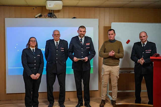 Bild: M&auml;nner und Frauen in blauen Feuerwehruniformen. 