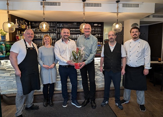  Fidan Osmani (3.v.li.) freute sich mit seinem Team &uuml;ber die Gl&uuml;ckw&uuml;nsche durch B&uuml;rgermeister Steffen Grimm (3.v.re.) und Citymanagerin Kathrin Kilian (2.v.li.). (Foto: Janine Skara)