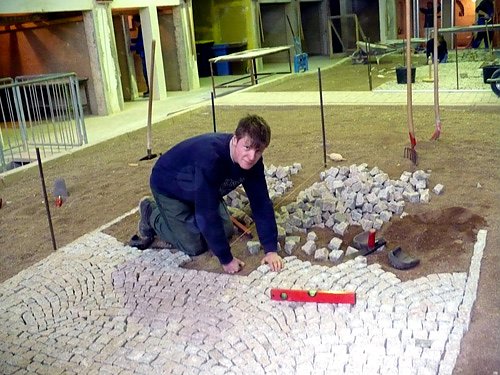 Kevin K&uuml;hnhold von der Tiefbaufirma G. Utsch aus Artern beim Verlegen von Natursteinpflaster.