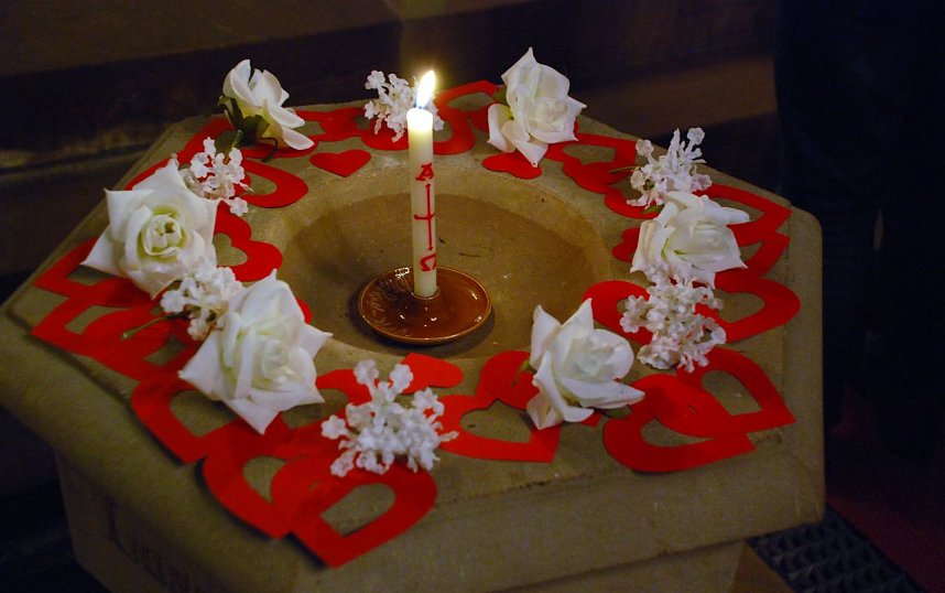 Das Taufbecken schm&uuml;ckten Herzen, Rosenbl&uuml;ten und eine Kerze.