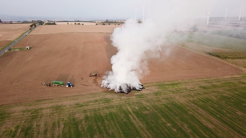 Brennende Strohballen zwischen Holz- und Kirchengel