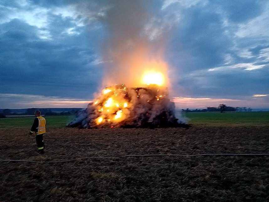 Brennende Strohballen zwischen Holz- und Kirchengel