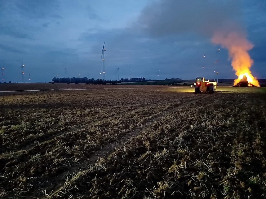 Brennende Strohballen zwischen Holz- und Kirchengel