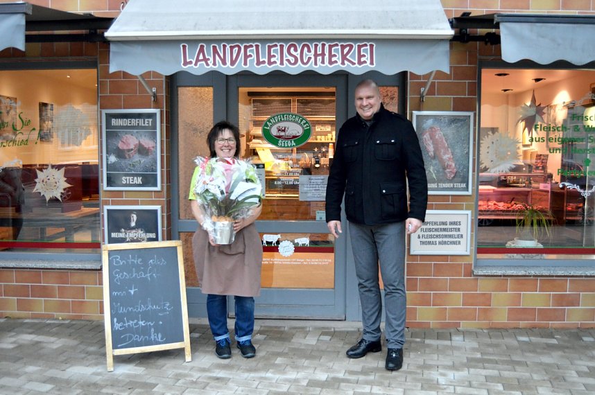 B&uuml;rgermeister Grimm &uuml;berreicht Geschenk an die Inhaberin der Fleischerei H&ouml;rchne