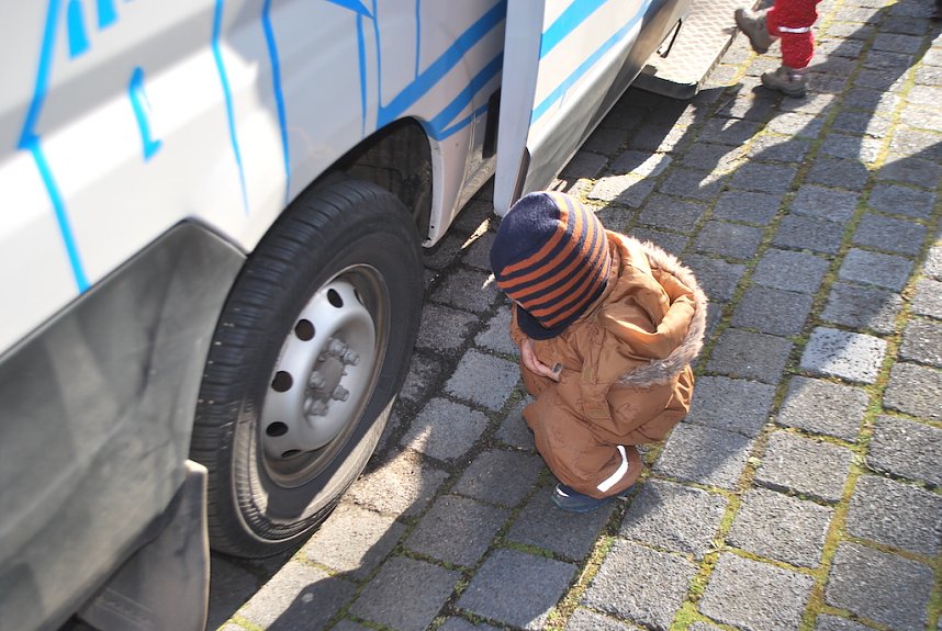 Die gro&szlig;en R&auml;der des Busses werden bestaunt